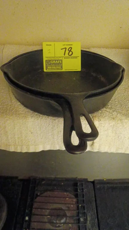 Cast iron skillets. Includes (2) cast iron skillets featuring dual pour spouts and handles with hanging holes.