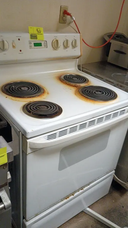 GE electric range. Features 4 coil heating elements, oven with viewing window, rear control panel with digital clock/timer, and lower storage drawer.