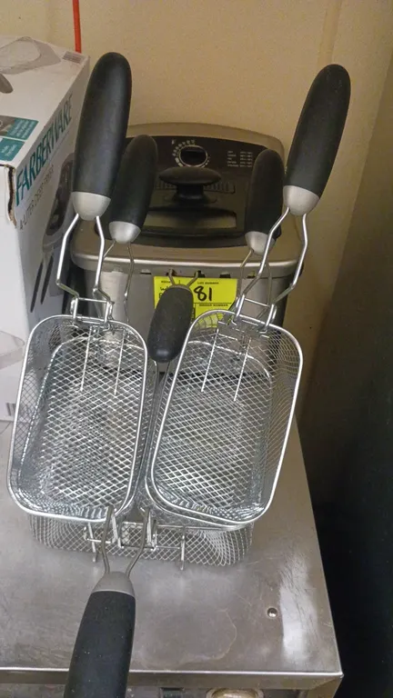 Farberware 4L electric deep fryer. Features immersion heating element, adjustable temperature control dial, indicator lights, lid with viewing window,
