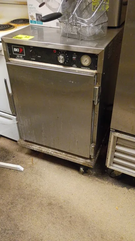 BKI HC-36 heated holding cabinet. Features stainless steel construction, single solid door, analog thermometer, adjustable moisture vent, and internal