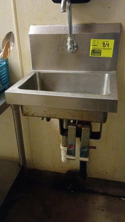 Stainless steel hand wash sink. Features gooseneck faucet, backsplash, and dual knee-pedal valves. Includes wall-mount Avair soap dispenser and Tork p