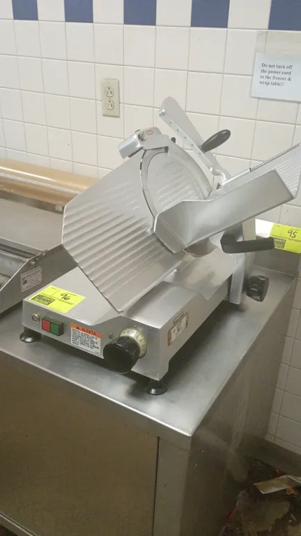 Berkel 827 manual gravity feed deli slicer. Features gravity-feed carriage, integrated product pusher, and adjustable slice thickness control. S/N: 97