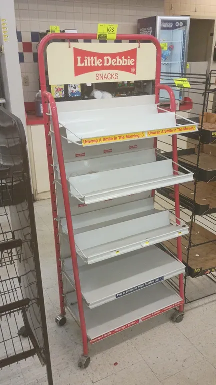 Little Debbie 5-tier metal portable merchandise display rack. Features red tubular metal frame, Little Debbie Snacks header sign, and 5 metal shelves