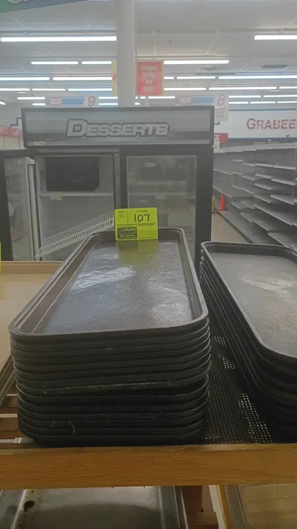 Poly bakery display trays. Features molded composite construction with raised rim edges and textured surface.