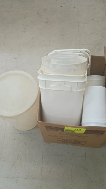 Assorted plastic food storage containers. Includes square and round pails, tubs, and lids in various sizes.
