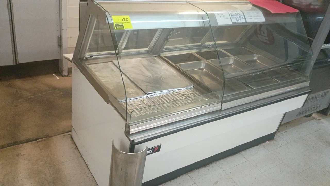 1997 BKI HDC4/2L hot deli display case. Features curved glass front, stainless steel food pan inserts, and interior lighting. Dimensions: 70" x 36" x