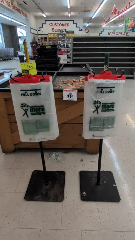 Metal double-sided produce bag stands. Features dual-sided wire hanging brackets for header produce bags. 4'H. Mounted on square metal base plates.