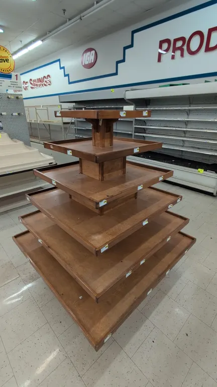 Wood 6-tier produce display table. Features tiered pyramid design with raised lip shelving and price tag molding. Dimensions: 4' x 5'H.