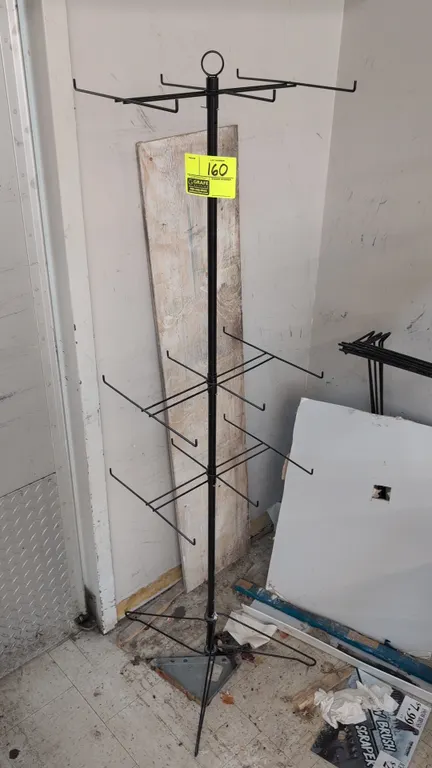 Metal merchandise display rack. Features multi-tier wire hanging hooks and top loop finial. Black finish. 64"H.