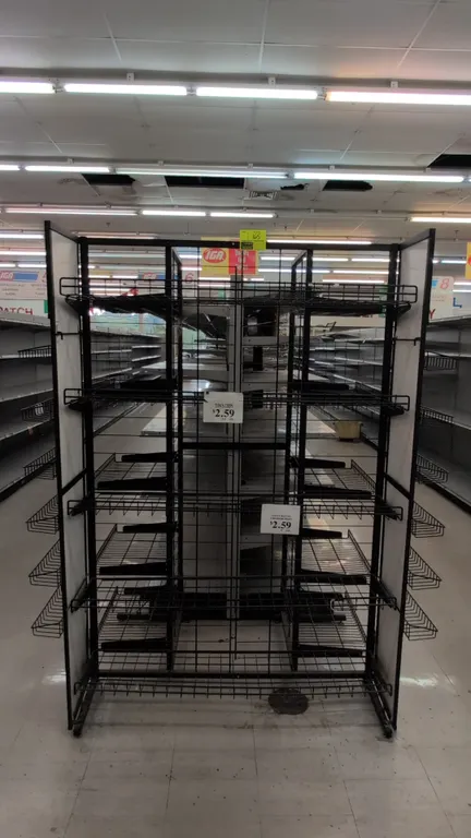 Metal merchandise display rack. Features double-sided adjustable wire shelving, side wire display baskets, and Lance and Tom's header signage. Black m