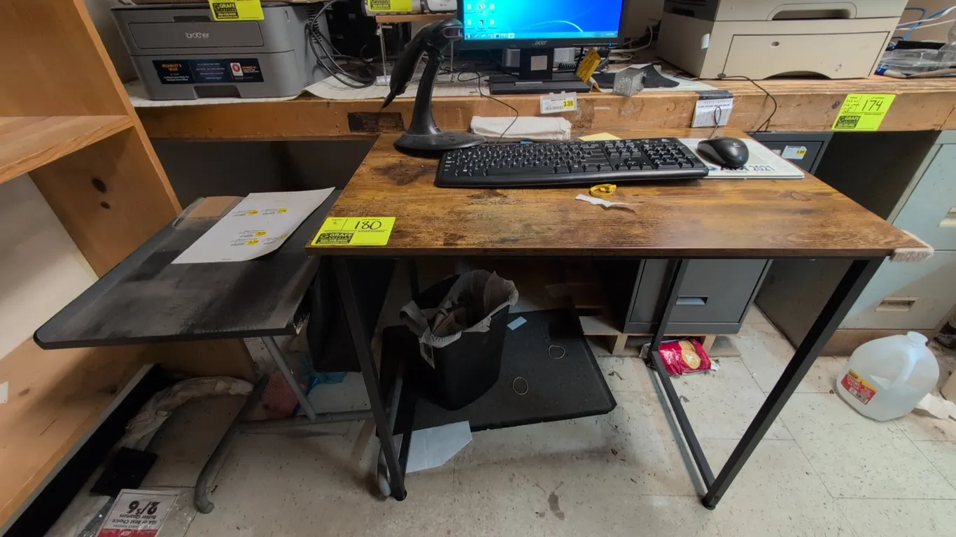 Assorted tables. Includes a writing desk featuring a rustic wood-grain laminate top with a black metal frame, and a utility stand featuring a lipped t