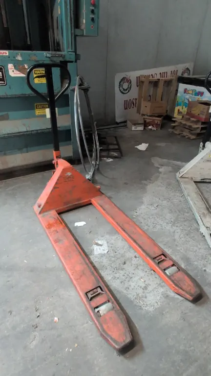 Manual hydraulic pallet jack. Features steel construction, loop handle with 3-position hand control lever, dual steer wheels, and single fork load rol