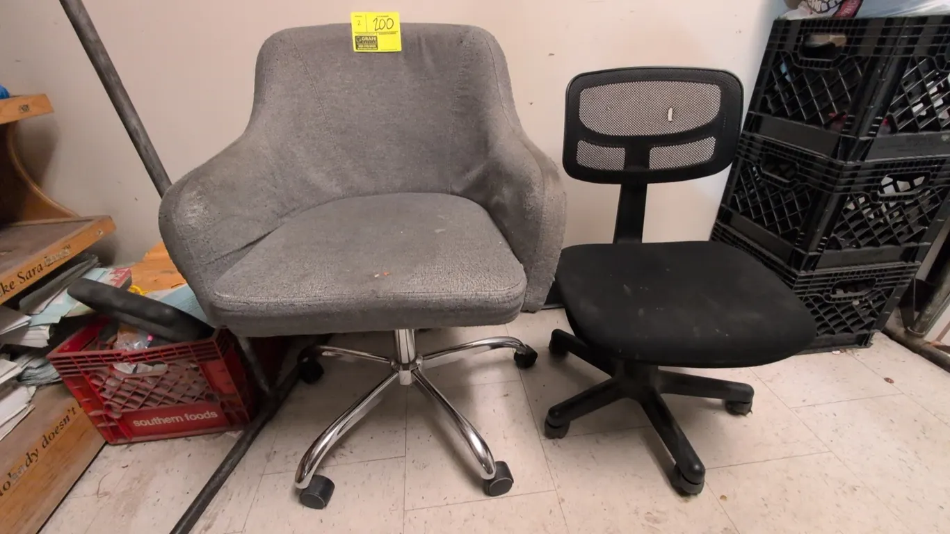 Assorted swivel office chairs. Includes a gray upholstered tub chair with a chrome 5-star rolling base and an armless black mesh-back task chair with