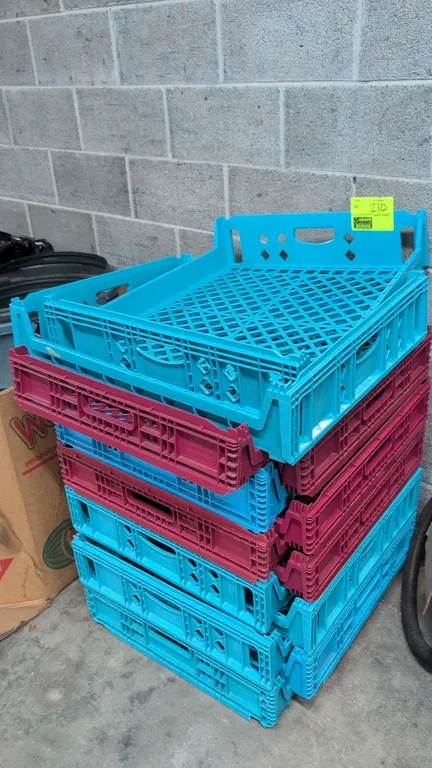Poly crates. Features stackable molded plastic construction with ventilated grid bottoms and integrated hand handles. Includes blue and maroon units.