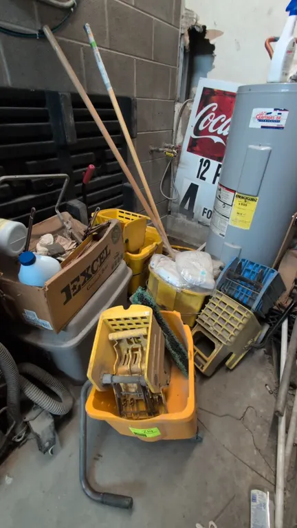 Assorted janitorial cleaning supplies. Includes rolling plastic mop buckets with wringers, additional mop wringers, wooden handles, packaged replaceme
