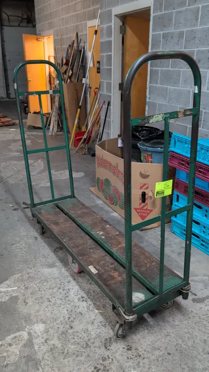 Metal U-boat stocking cart. Features dual tubular steel handles and a channel metal deck. 5'L. Mounted on center rigid wheels with corner swivel caste