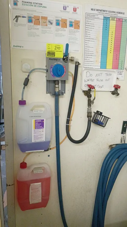 Rushing chemical foaming station. Features selector dial for wash, rinse, and sanitize operations, dual chemical intake lines, and blue washdown hose.
