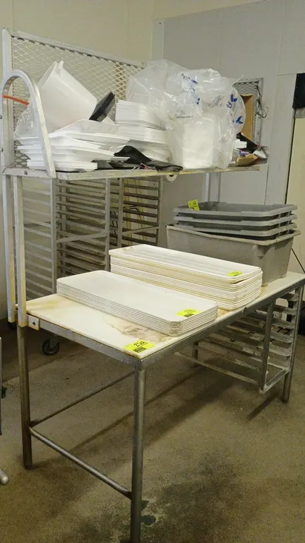 Aluminum prep table with top rack. Features poly cutting board surface, overhead shelf with expanded metal back, and integrated lower sheet pan slides