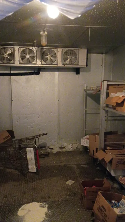 Walk-in freezer. Features a 4-fan evaporator coil, diamond tread flooring, 2 fire sprinkler heads, and interior lighting. Dimensions: 176" x 135" x 96
