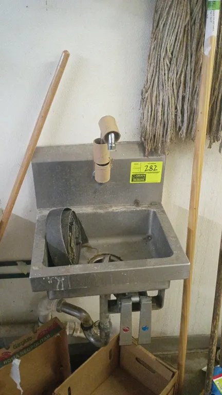 Stainless steel hand wash sink. Features splash-mount gooseneck faucet, dual knee pedal valves, and splash guard. Includes wall-mounted paper towel di