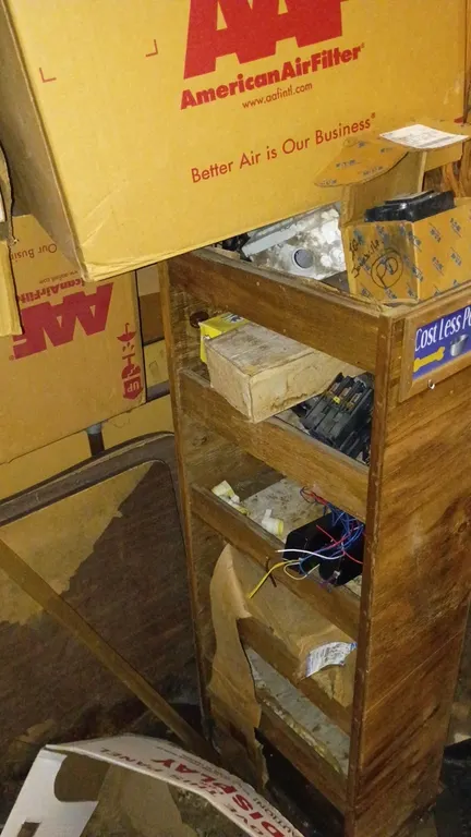 Assorted supply and fixture lot. Includes rolls of register paper, assorted electrical fuses, and a vertical multi-tier wooden display rack. Note: Tab
