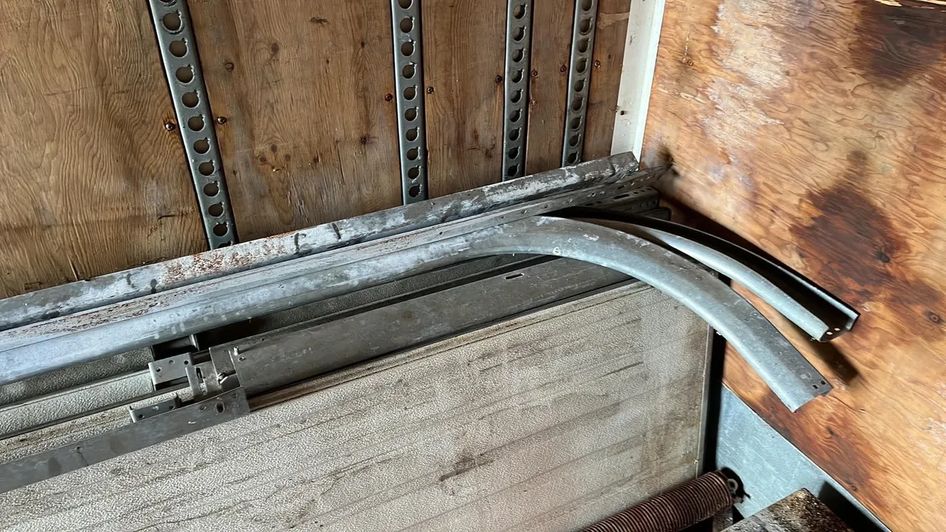 OFFSITE - Garage door, 10’ wide and 12’ high. Missing 1 track and rollers.