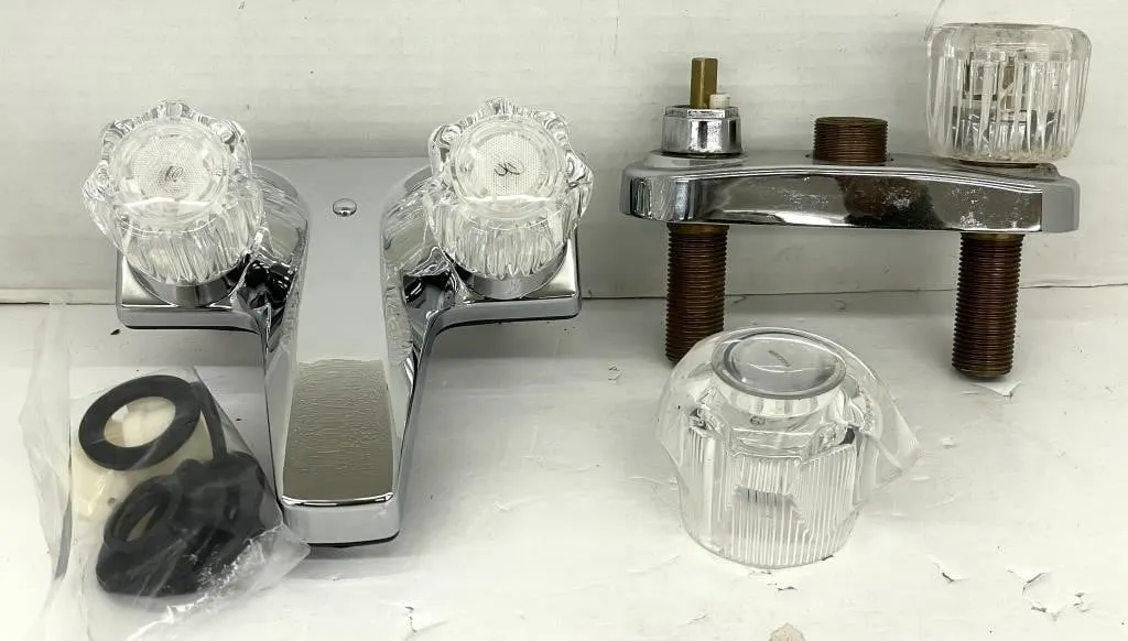 Two bathroom sink tap sets. One is incomplete.