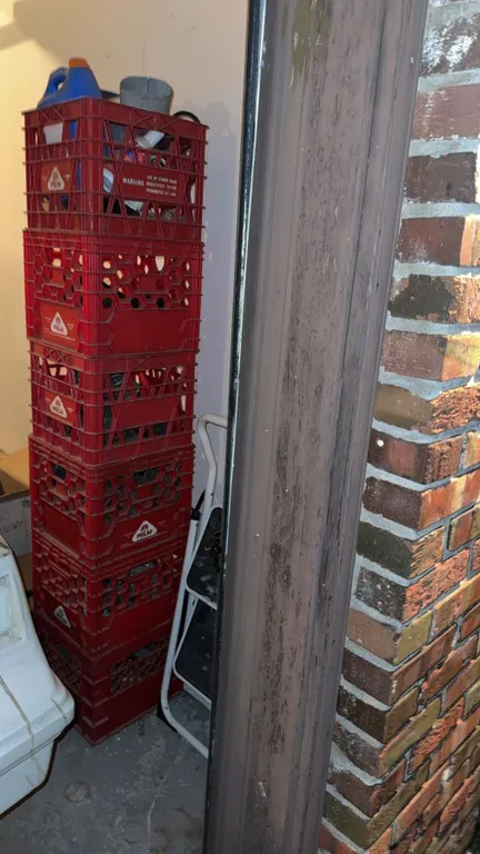 Stack of Palm Red Plastic Milk Crates and Folding Step Stool