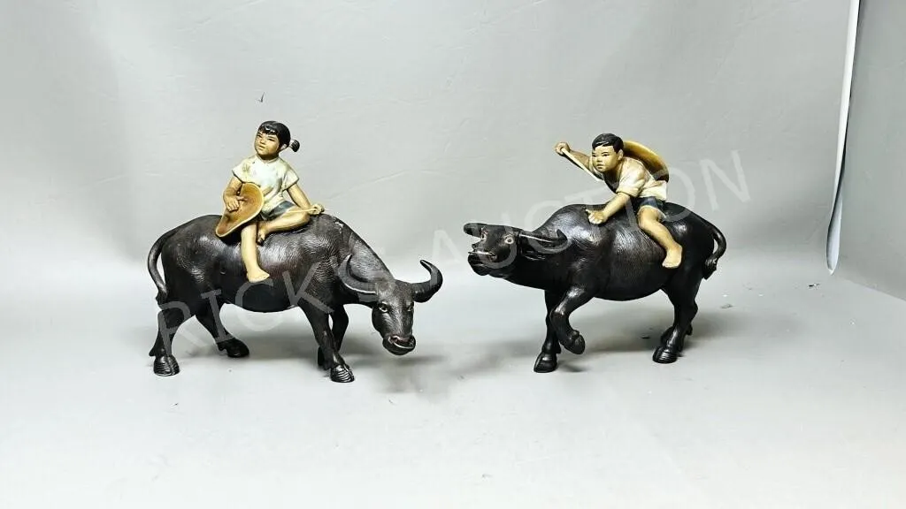 pair of mudman figures children on water buffalo