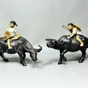 pair of mudman figures children on water buffalo