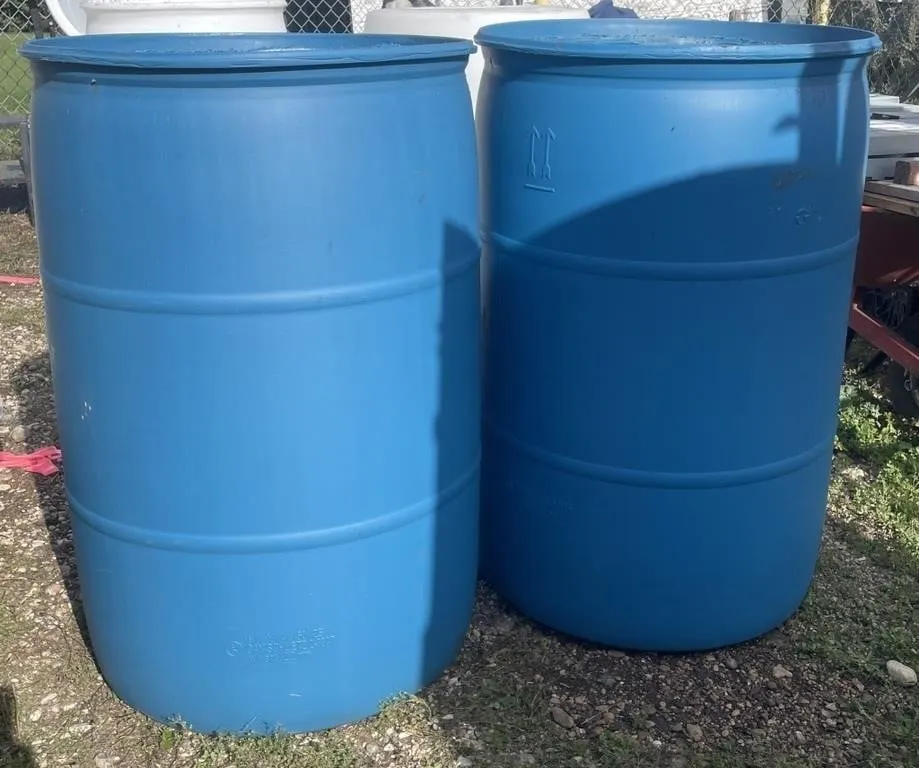 Pair of blue 50 gallon water barrels.