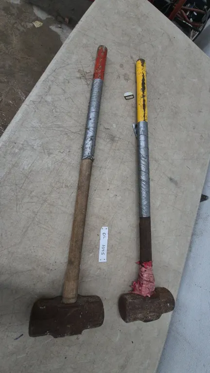 Two Sledgehammers, One with Red-Painted Handle, One with Yellow-Painted Handle