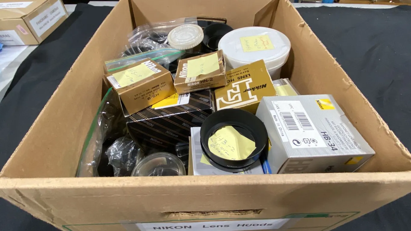BOX OF ASSORTED NIKON LENS HOODS & PLASTIC LENS CASES