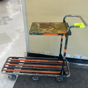 Metal stocking cart. Features tubular steel frame, lower slatted deck, elevated top shelf, and push handle. 44"L. Mounted on casters. Note: Upper shel