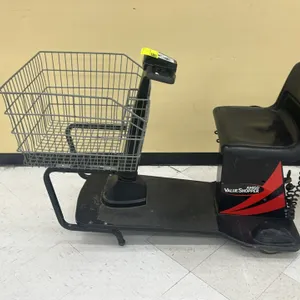 Amigo Value Shopper motorized shopping cart. Features front wire shopping basket, molded plastic seat, handlebar controls, and integrated coiled charg