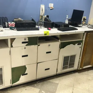 Laminate counter with lower cabinets and drawers. Features white laminate countertop with wire pass-through grommets, built-in storage cabinets with v
