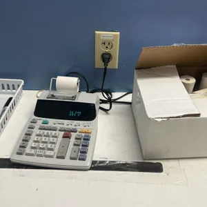 Office accessories and desk organizers. Includes Sharp electronic printing calculator, Bixolon receipt printer, black wire mesh desk organizer trays a