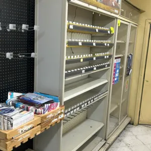 Metal multi-tier tobacco merchandiser. Features Marlboro graphic header, adjustable metal shelving with spring-loaded product pushers, integrated pric