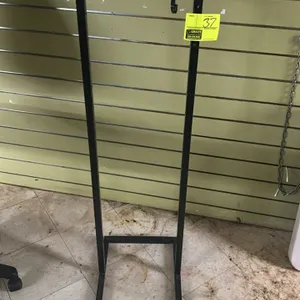Freestanding two-sided metal display rack. Features black painted tubular steel frame, top-mounted dual hanging bracket, and a stabilizing floor base.