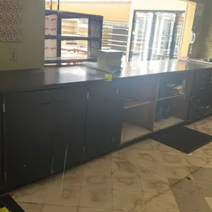 Laminate countertop with base cabinets. Features a black laminate surface, 3 lower cabinet doors, open storage shelving compartments, and integrated d