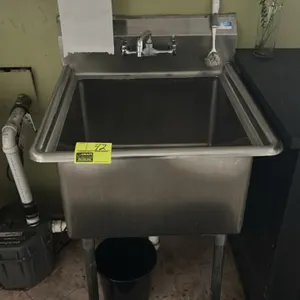 Stainless steel handwashing sink. Features a single compartment, integrated backsplash, splash-mount faucet, and tubular metal legs with adjustable bu