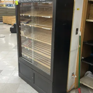 Wooden cigar and tobacco merchandiser cabinet. Features 'PREMIUM CIGARS' header graphic, sliding glass display doors, slatted wood shelves, lower 2-do