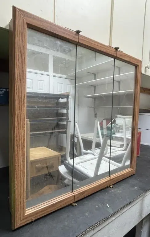 Tri-fold mirrored cabinet. Wood-look finish.