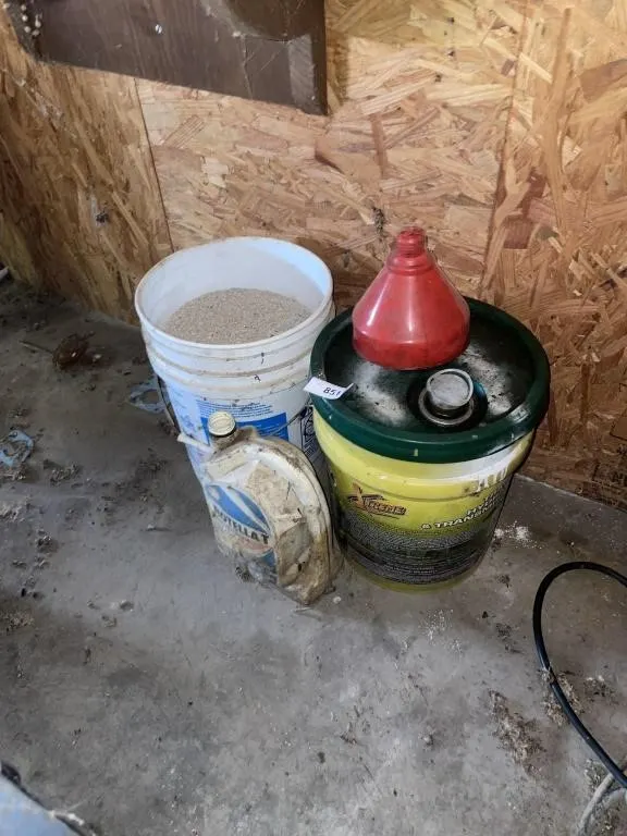 Bucket of hydraulic fluid, floor dry, funnel