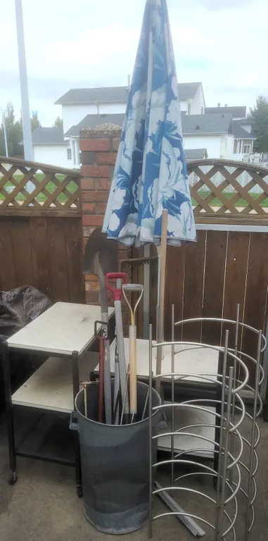 Outdoor Lot With Blue Patio Umbrella, Yard Tools, Rolling Tables