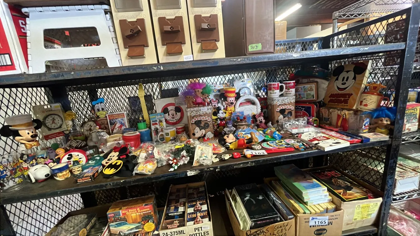 SHELF OF ASSORTED VINTAGE MICKEY MOUSE COLLECTABLE ITEMS INCL. MUGS, KEYCHAINS, FIGURINES AND MORE
