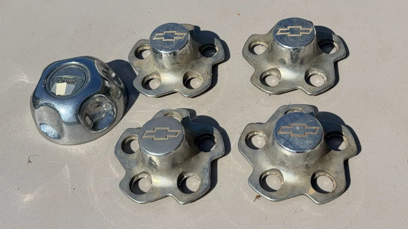 Four Chevy and One Ford Hubcap