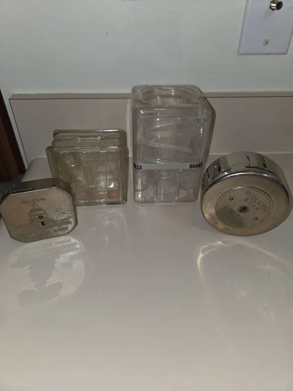 4 small, assorted glass metal and plastic coinbanks.