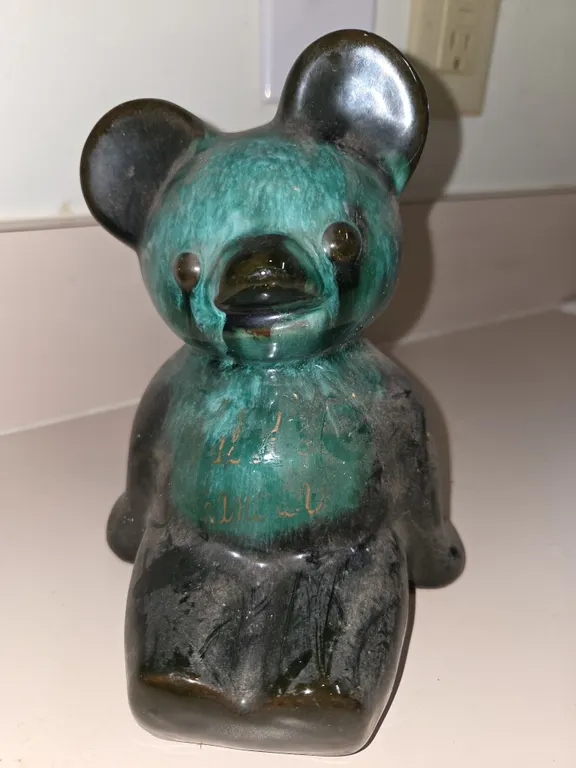 Vintage Canadian art pottery sitting bear. With black and green glaze. Mid 20th century.