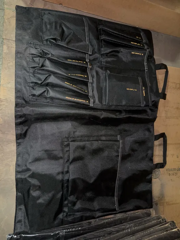 Tool carrying bag with various labeled compartments for different tools